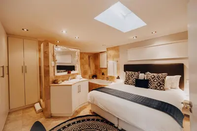 a bedroom with a large bed and a bathroom at 22 Eikehoff Apartment in Stellenbosch