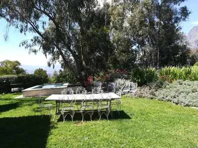 a table and chairs sitting in the grass in a yard at Skyview Manor in Stellenbosch