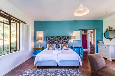 a bedroom with a bed and a blue wall at Skyview Manor in Stellenbosch