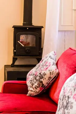 a red couch with a pillow next to a stove at Skyview Manor in Stellenbosch