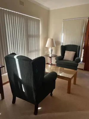 a living room with two chairs and a coffee table at Hermanus Heights Villa in Hermanus