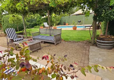 two benches sitting in a yard with a pool at Rawsonville House in Rawsonville