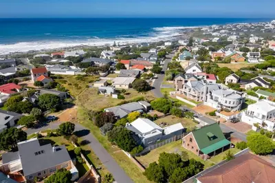 an aerial view of a residential suburb with the beach at Onrus Cottage in Hermanus