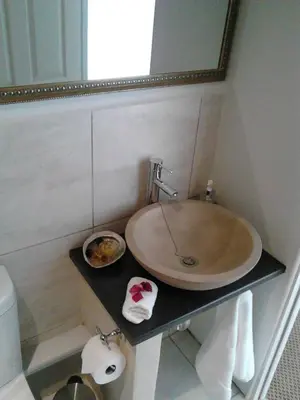 a bathroom with a sink and a mirror at Port House in Bloubergstrand