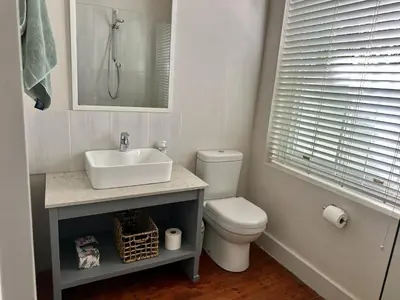 a white bathroom with a sink and a toilet at Le Manse in Franschhoek