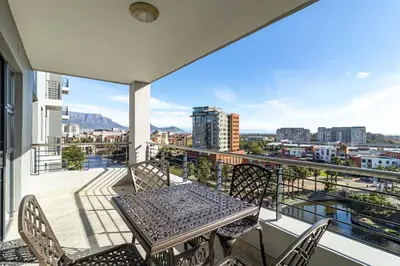 a balcony with a table and chairs and a view at Citystay Apartments Century City in Cape Town