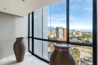 two large vases sitting in front of a window at Citystay Apartments Century City in Cape Town