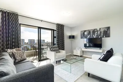 a living room with a couch and a tv at Citystay Apartments Century City in Cape Town