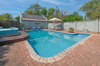 a swimming pool with blue water in a yard at 6 Stemmet Lodge in Hermanus
