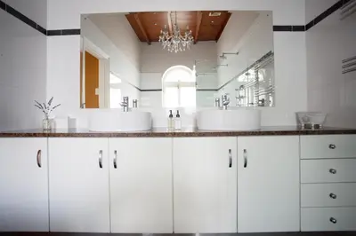 a white bathroom with two sinks and a mirror at Beckhuis in Worcester