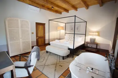 a bedroom with a bed and a tub in a room at Beckhuis in Worcester