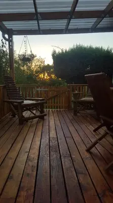 a wooden deck with two benches and a picnic table at Frieden-Hof Guest Accommodation in Penhill