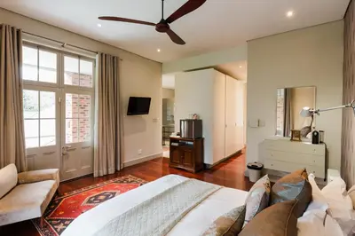a large bedroom with a bed and a couch at Marshden Estate in Stellenbosch