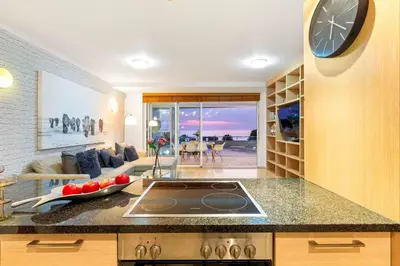 a kitchen with a large clock on the wall at Horizon Bay 103 in Bloubergstrand