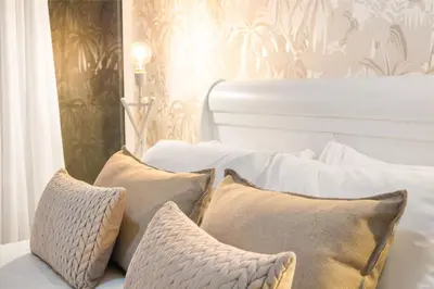 a white bed with three pillows on it at Horizon Bay 103 in Bloubergstrand