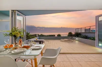 a dining room with a view of the ocean at Horizon Bay 103 in Bloubergstrand