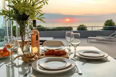 a table with a bottle of wine and plates and wine glasses at Horizon Bay 103 in Bloubergstrand
