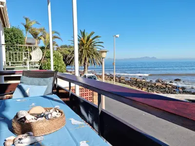 a basket of shells on a table next to the beach at Bikini Beach Holiday Home, On the Beach, Sleeps 9! in Gordonʼs Bay