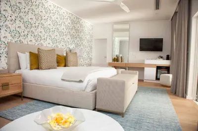 a bedroom with a bed and a living room at La Petite Ferme in Franschhoek