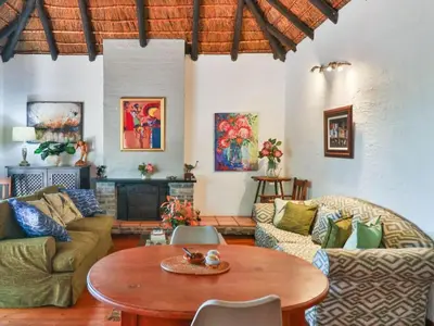 a living room with couches and a wooden table at House on Westcliff in Hermanus