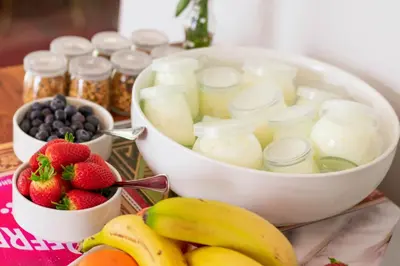 a table topped with two containers of yogurt and fruit at Rozenburg Guest House in Stellenbosch
