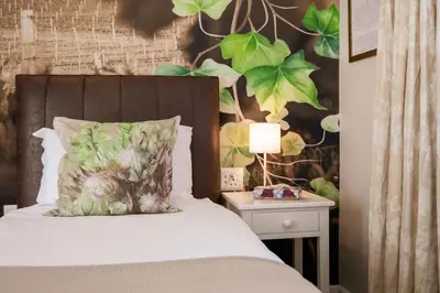 a bedroom with a bed with a plant wall at Rozenburg Guest House in Stellenbosch