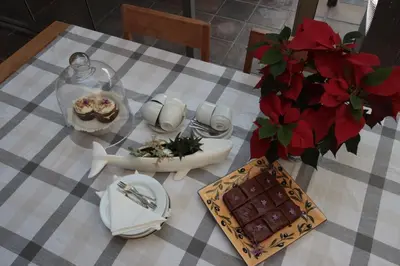 a table with a plate of food and a vase of flowers at On The Cliff Guest House in Hermanus