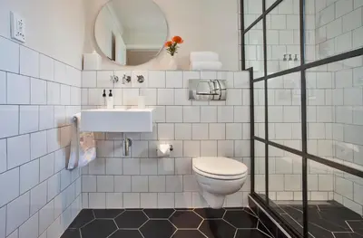 a bathroom with a toilet and a sink and a mirror at Sugarbird Manor in Stellenbosch