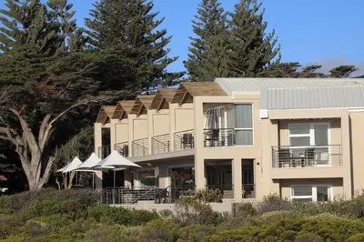 a large house with trees in front of it at Abalone Guest Lodge in Hermanus
