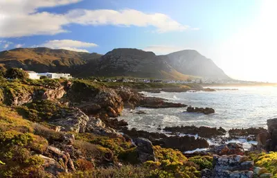 a view of the ocean with mountains in the background at Abalone Guest Lodge in Hermanus