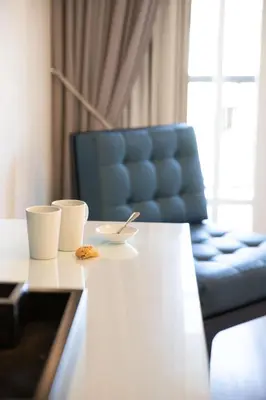 a table with two cups and a blue chair at Protea Hotel by Marriott Franschhoek in Franschhoek