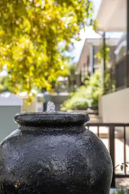 a black vase sitting in front of a building at Protea Hotel by Marriott Franschhoek in Franschhoek