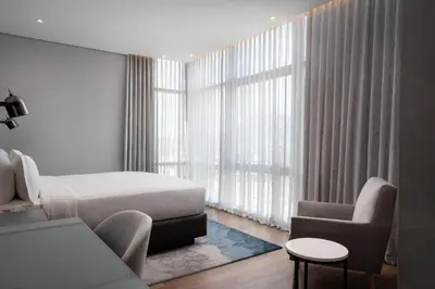 a bedroom with a bed and a chair and a window at Cape Town Marriott Hotel Crystal Towers in Cape Town