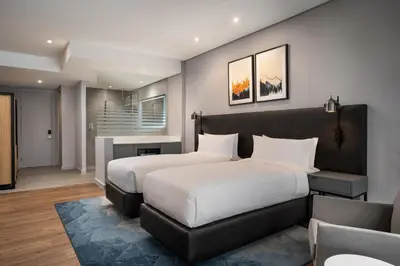 a bedroom with a large bed and a couch at Cape Town Marriott Hotel Crystal Towers in Cape Town