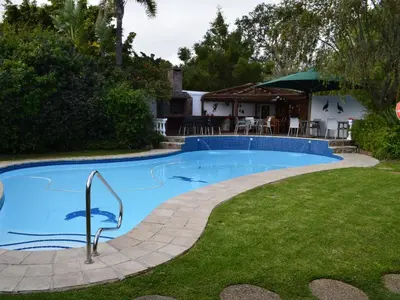a swimming pool in the yard of a house at Somer Place B&B in Somerset West