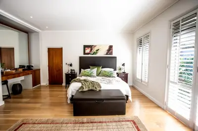 a bedroom with a bed and a large window at Selkirk House in Hermanus