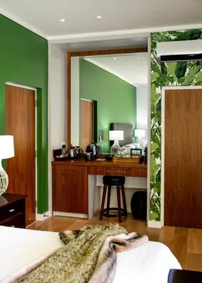 a bedroom with green walls and a desk with a mirror at Selkirk House in Hermanus