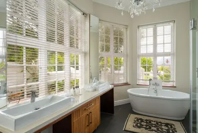 a bathroom with two sinks and a tub and windows at Wild Mushroom Country House in Stellenbosch