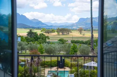 a window with a view of a field and mountains at Wild Mushroom Country House in Stellenbosch