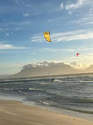 two people are flying kites on the beach at OCEAN BREEZE SUNSET BEACH - Cape Town in Cape Town
