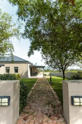 a stone path leading to a house with a tree at Bona Vista Self-Catering Accommodation in Klapmuts
