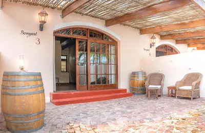 a building with barrels in front of a door at De Leeuwenhof Estate in Paarl