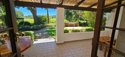 an open door to a patio with a view of a yard at De Leeuwenhof Estate in Paarl