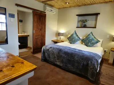 a bedroom with a large bed in a room at De Leeuwenhof Estate in Paarl