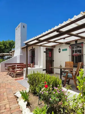 a patio of a house with a table and chairs at De Leeuwenhof Estate in Paarl