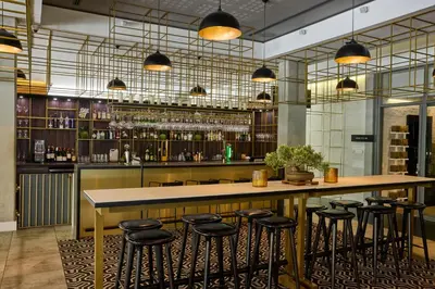 a bar with bar stools in a room at Century City Hotel Urban Square in Cape Town