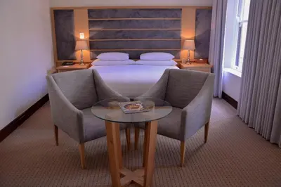 a hotel room with a bed and a table and chairs at ASARA Wine Estate & Hotel in Stellenbosch