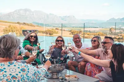 a group of people sitting around a table drinking wine at ASARA Wine Estate & Hotel in Stellenbosch