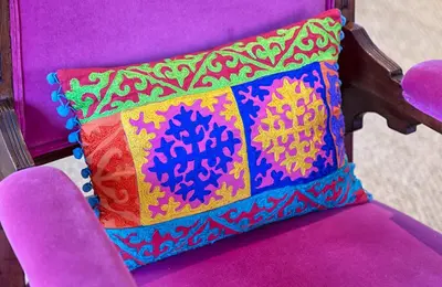 a colorful pillow sitting on a purple chair at The Vishuis in Hermanus