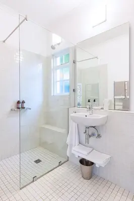 a white bathroom with a sink and a shower at The Vishuis in Hermanus